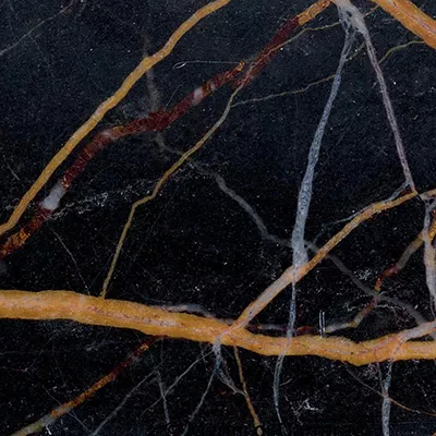 Close-up Black And Gold Granite: black granite with irregular veins in shades of gold, white, and rust, featuring a polished and glossy surface.