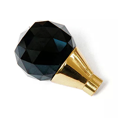 A close-up of a faceted black glass pull knob with a gold-toned base, showcasing Koket's Burlesque Black Glass Pull.