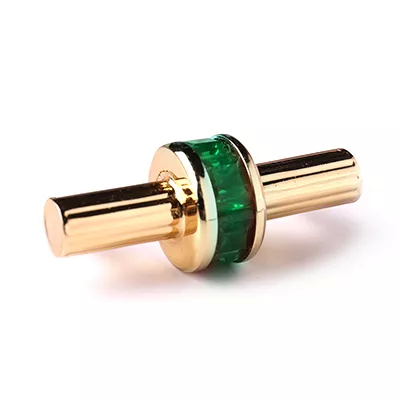 A close-up of a decorative handle with an emerald green stone set in gold-toned metal, showcasing Koket's Exotica Handle Emerald.