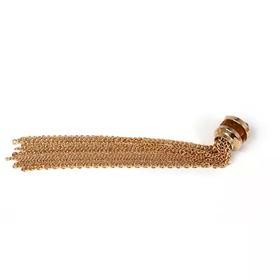 Exotica Jewel Appliqué Amber: golden chain tassel attached to aged brass piece with amber enamel details.