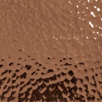 Close-up Hammered Copper (Gloss): copper surface with an irregular hammered texture, featuring bumps and shiny reflections.