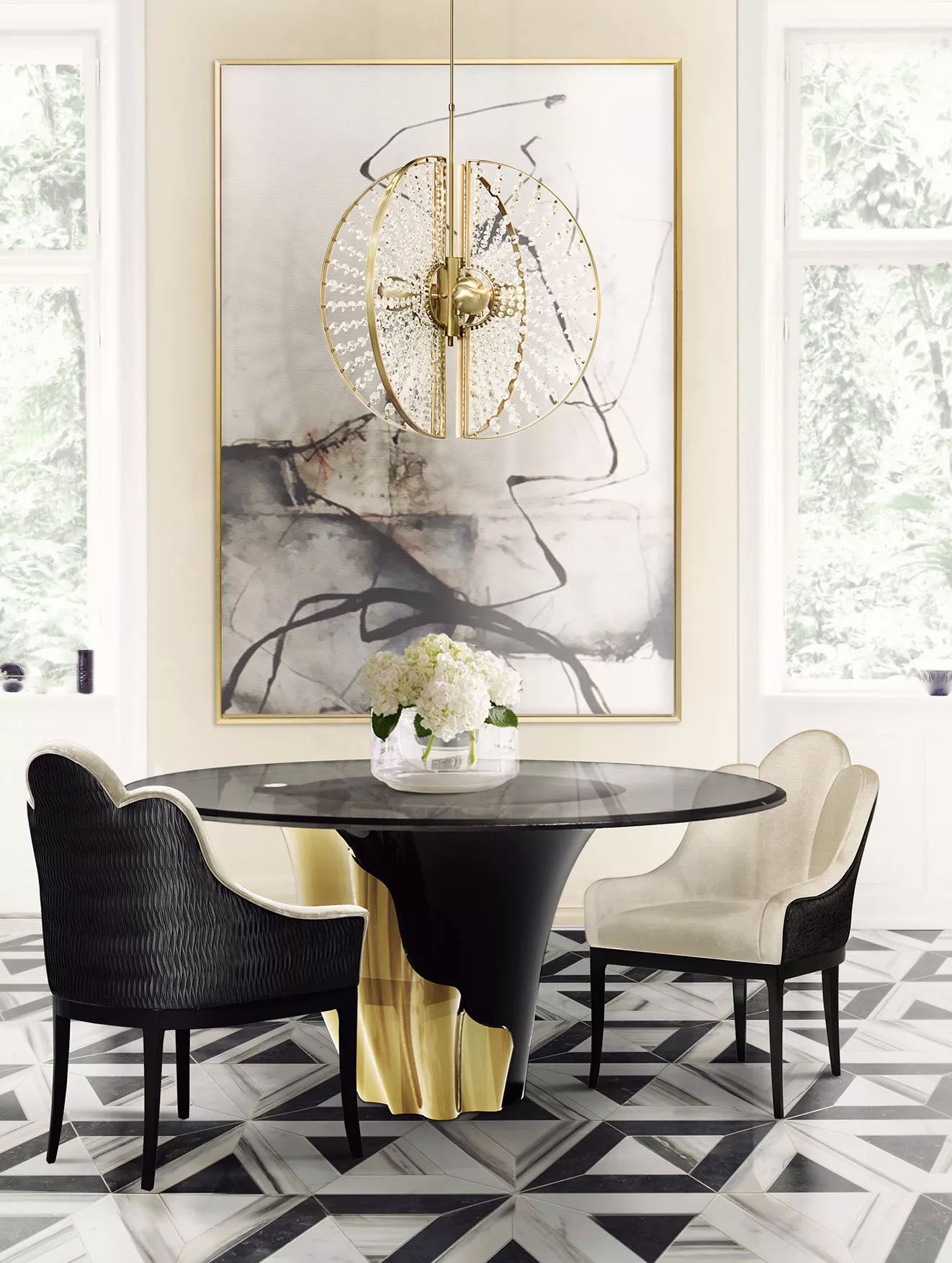 A bright dining room with luxurious golden features. In the center, there’s a Yasmine Dining Chair with glass tabletop, a black structure and a golden detail that arches back and forth. Surrounding the Yasmine Dining Chair, there are two Anastasia Dining Chairs, with a black structure and white velvety upholstery.  Hovering over, there is a Roxy Chandelier, with a golden round structure and clear glass details. In the background there is a golden frame with artworks.