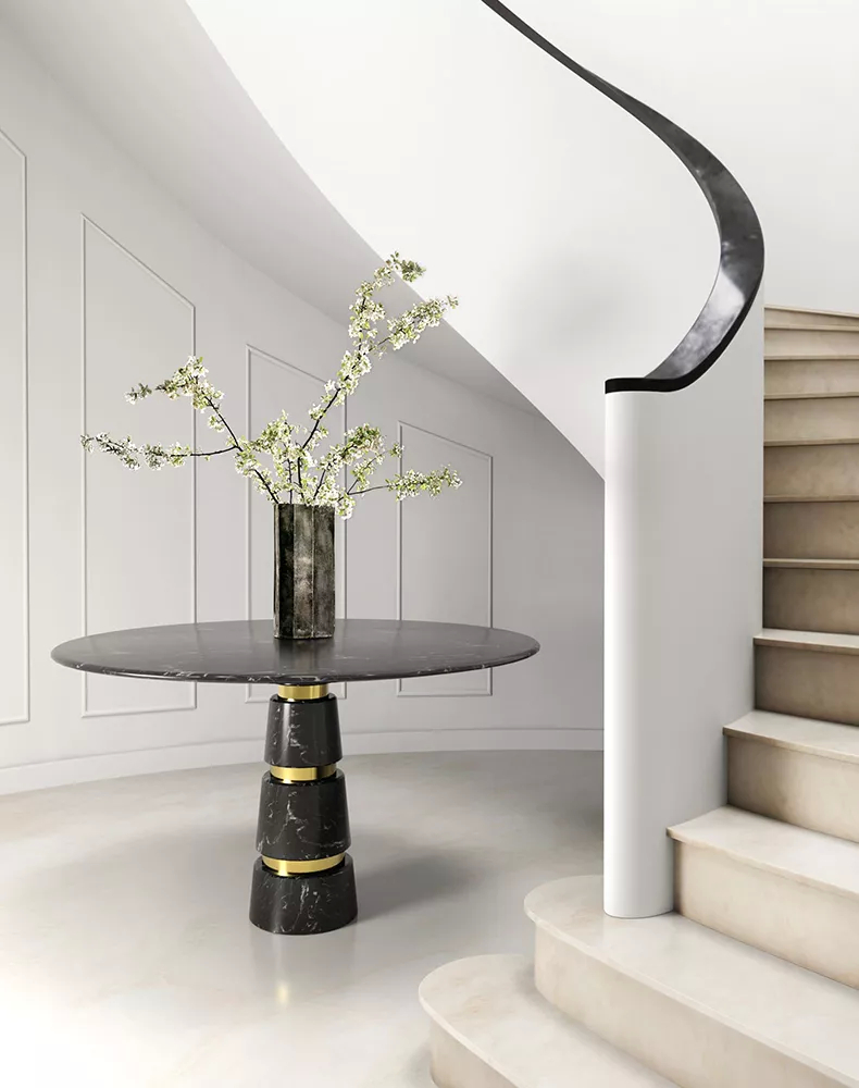 With refined simplicity, this entryway in neutral colors features an elegant curving staircase. The Avalanche Dining Table anchors the space with its dark surface with golden bands that gleam like quiet promises of luxury. Above there’s a bouquet of flowers that captures the nature’s soft touch. Every detail speaks of quiet sophistication.
