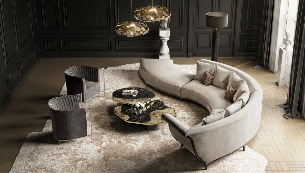 Luxurious living room with a curved beige sofa, two dark gray armchairs, and a marble and gold coffee table on a patterned rug.