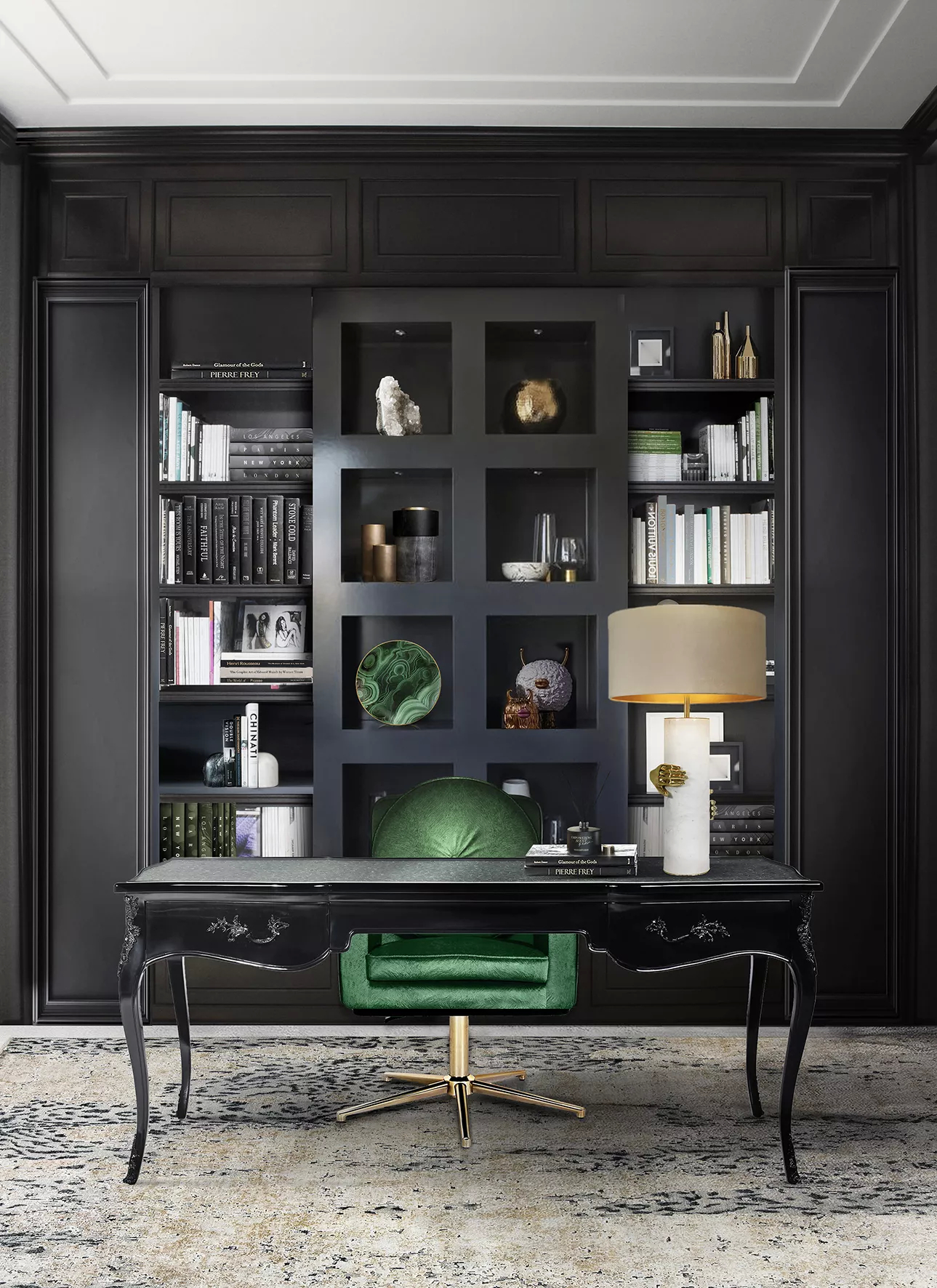 A home office in dark hues, with a full black wall in the background, adorned with accessories such as books, cups and others. In the center, there is a black Exotic Ormolu Desk, bringing elegance into the space with its details. On top of the desk, there is a Vengeance Table Lamp, featuring a white base and a cream lampshade.