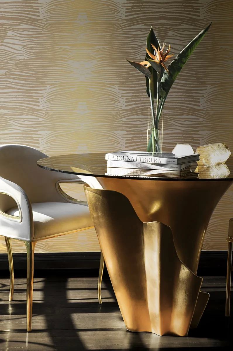 A opulent dining room features a Yasmine Dining Table by Koket with a black base and a Chandra Dining Chair.
