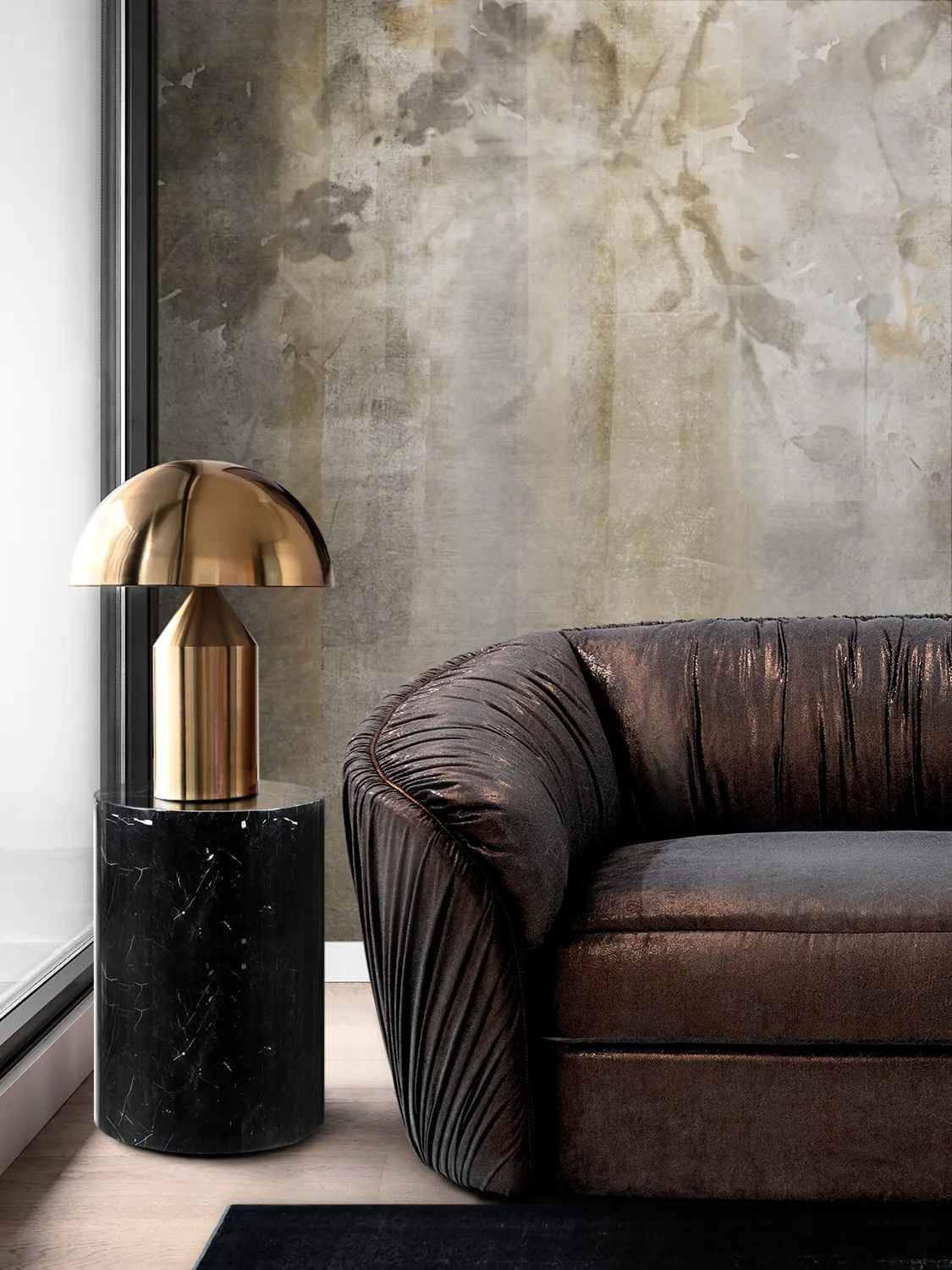 A detailed shot of a textured brown Luscious Sofa, next to a black marble side table with a gold mushroom lamp.