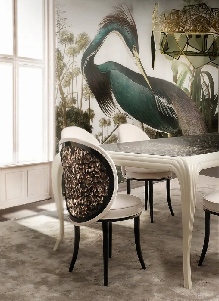 A lavish dining room features a long Merveille Dining Table by Koket surrounded by Merveille Chairs.