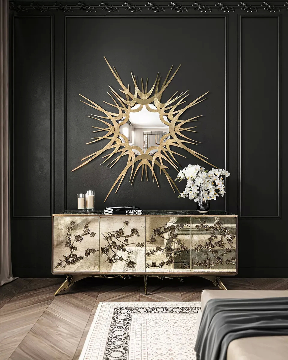 A glamorous room features a Spellbound Aged Mirror Cabinet and a Guilt Mirror by Koket, set against a dark paneled wall.