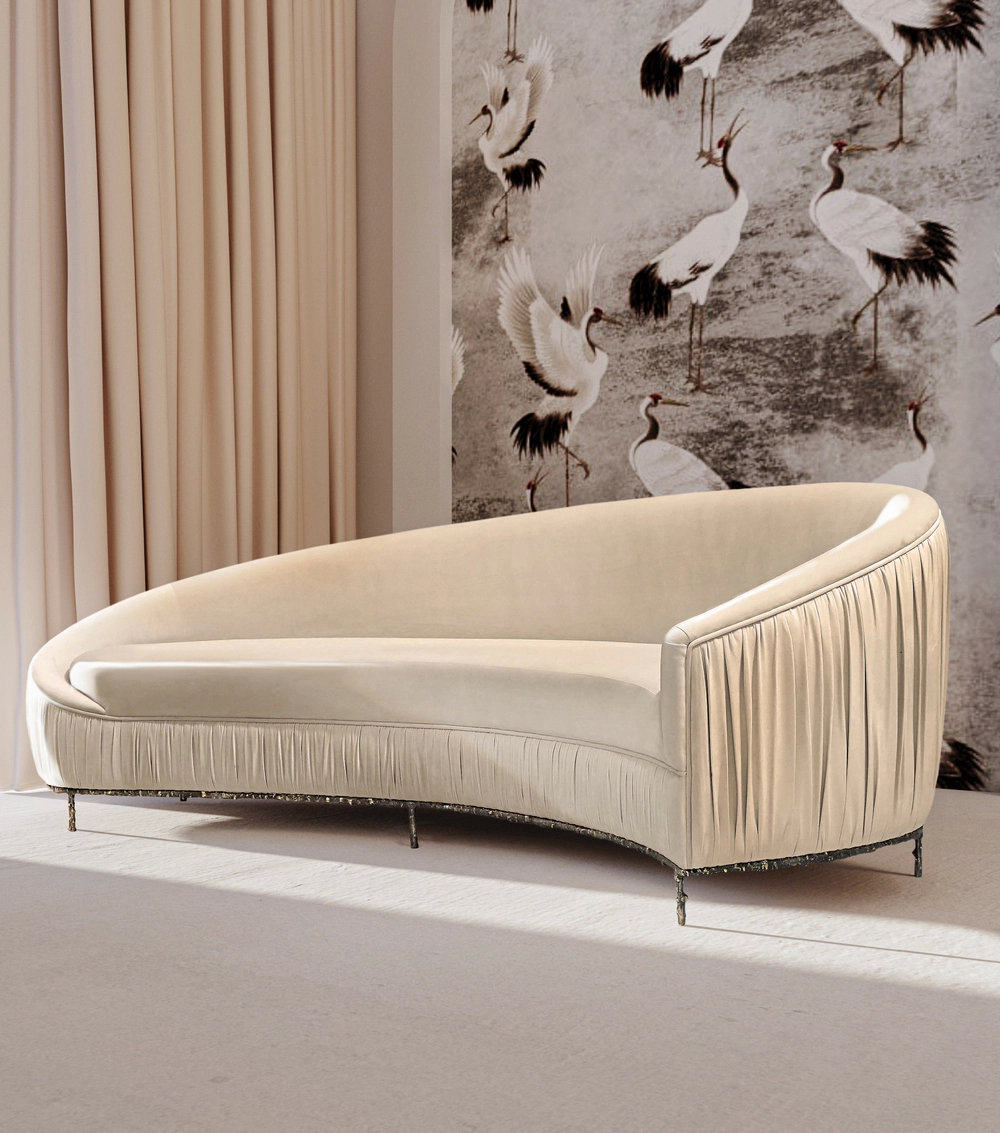 A white couch positioned in front of a wall decorated with various bird illustrations.
