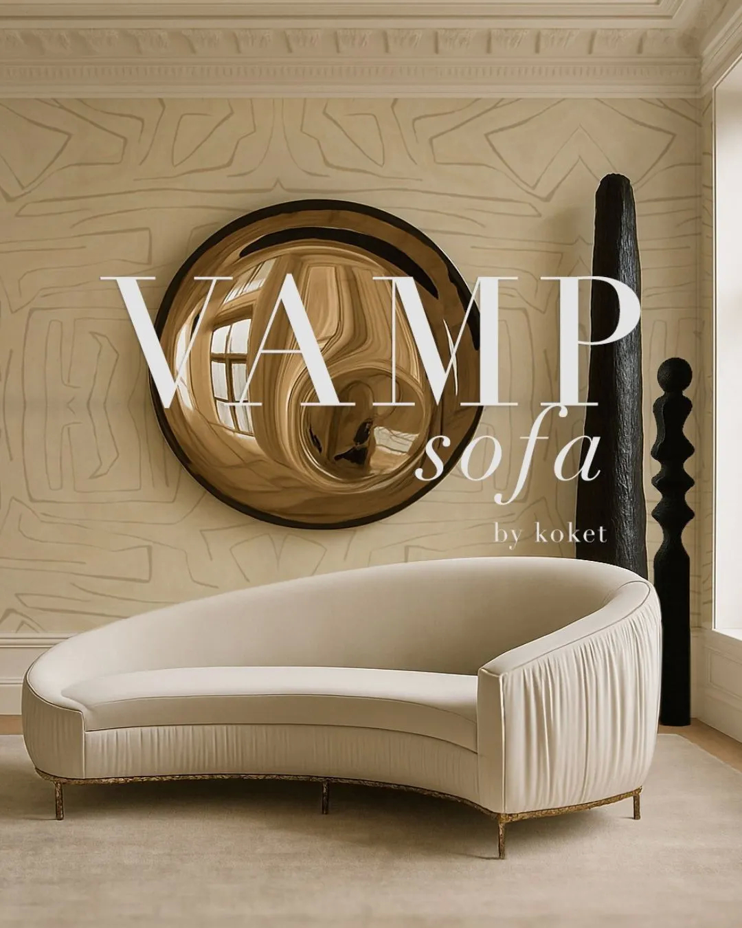 Elegant cream curved Vamp Sofa by KOKET with pleated sides and gold legs, featured in a chic interior with a large gold mirror and dark sculptural art, emphasizing luxury and modern design.