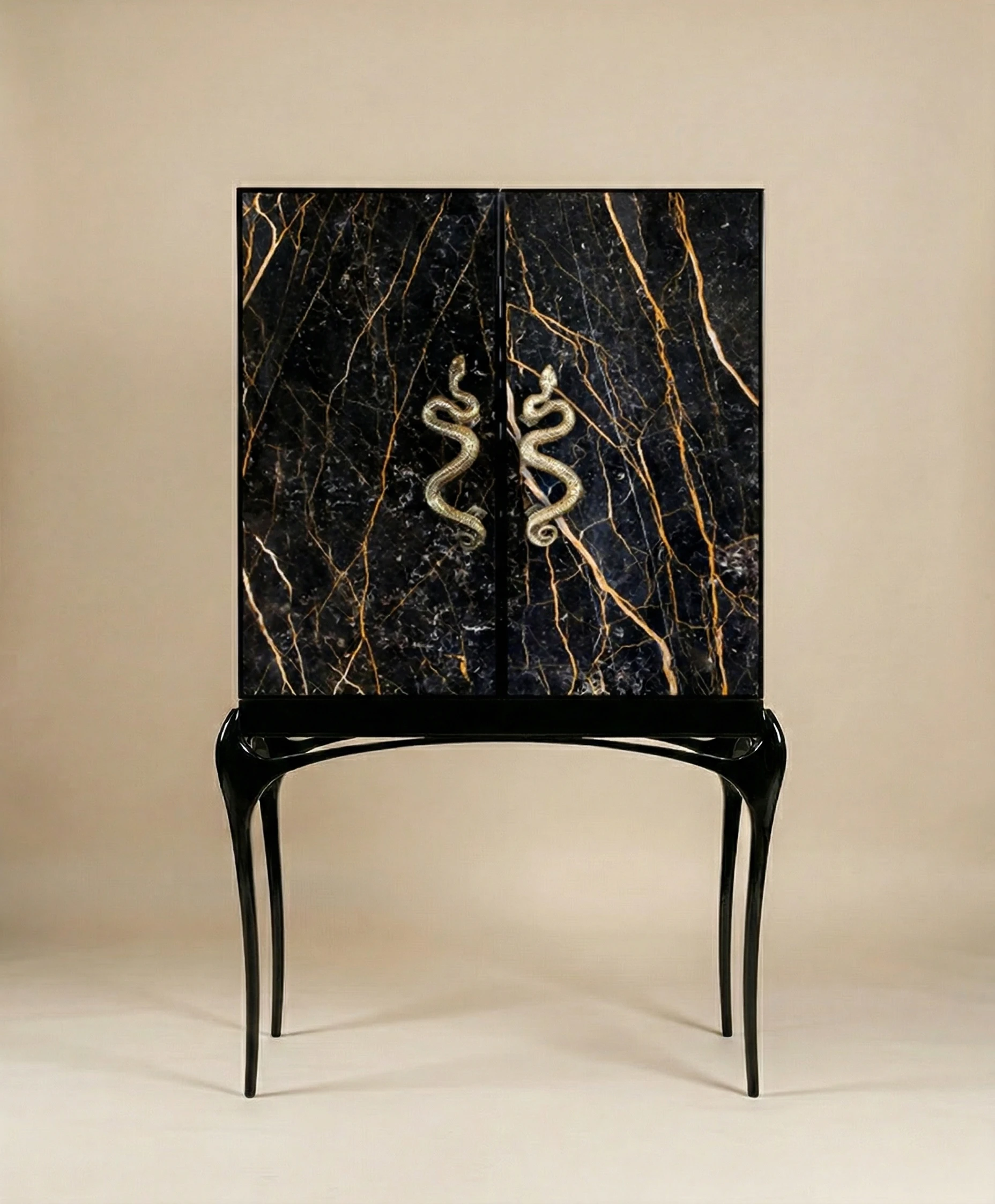 Luxury cabinet with black marble doors, gold veining, sculptural black legs, and snake-shaped brass handles on a neutral background.
