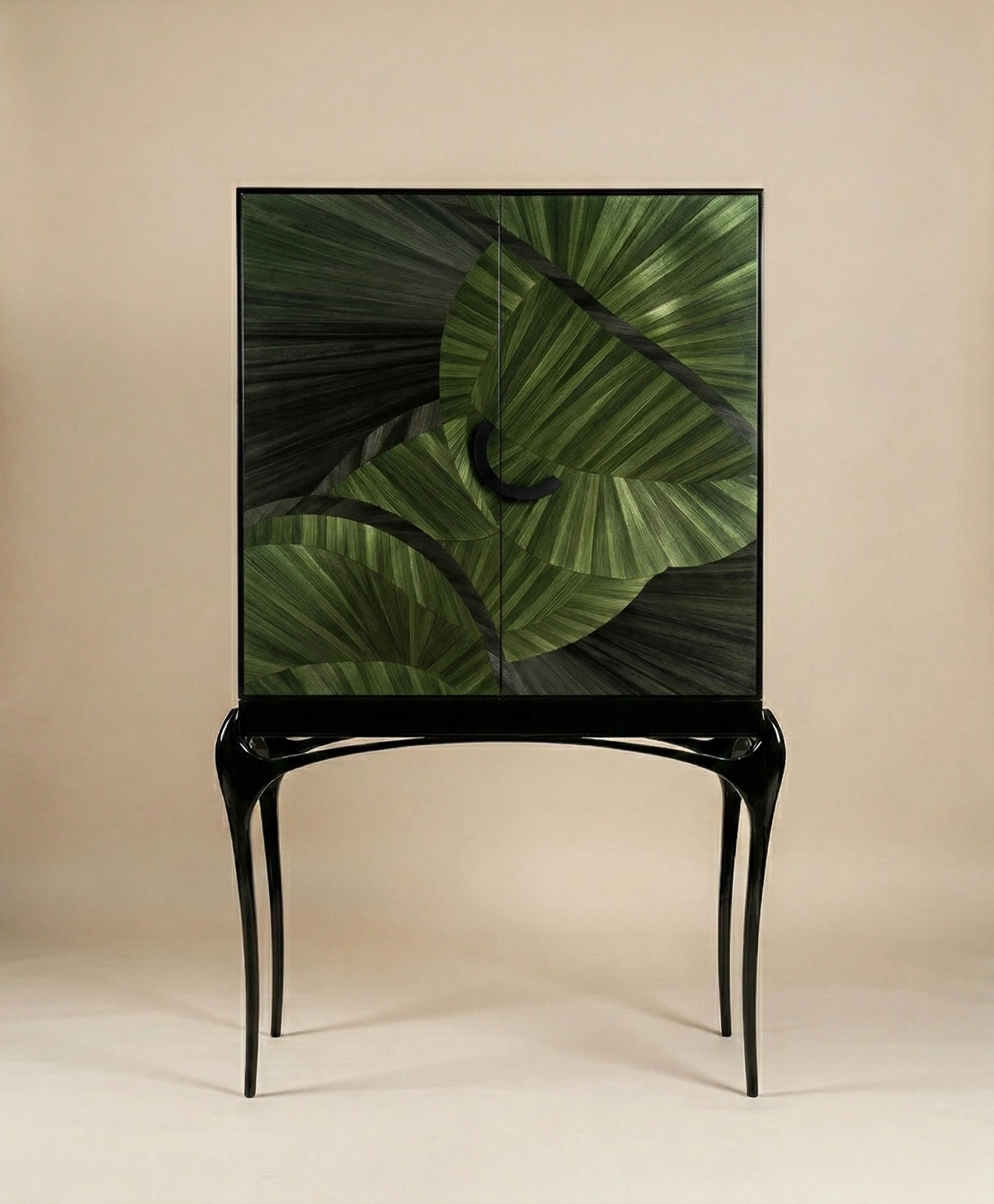 Luxury cabinet with green leaf-patterned marquetry doors, sculptural black legs, and a minimalist central handle on a neutral background.