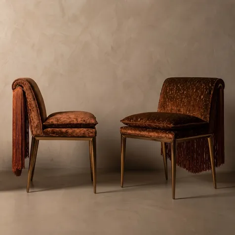 KOKET Women Art Deco luxury chairs with brown velvet upholstery, cascading fringe backs and elegant gold legs in a refined interior.