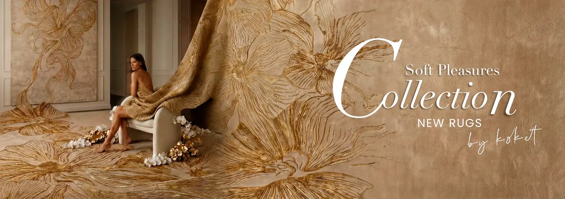 Luxury KOKET rug collection featuring an elegant beige and gold floral designer rug, styled in a refined interior with matching wall art and a model seated on a draped luxury rug.