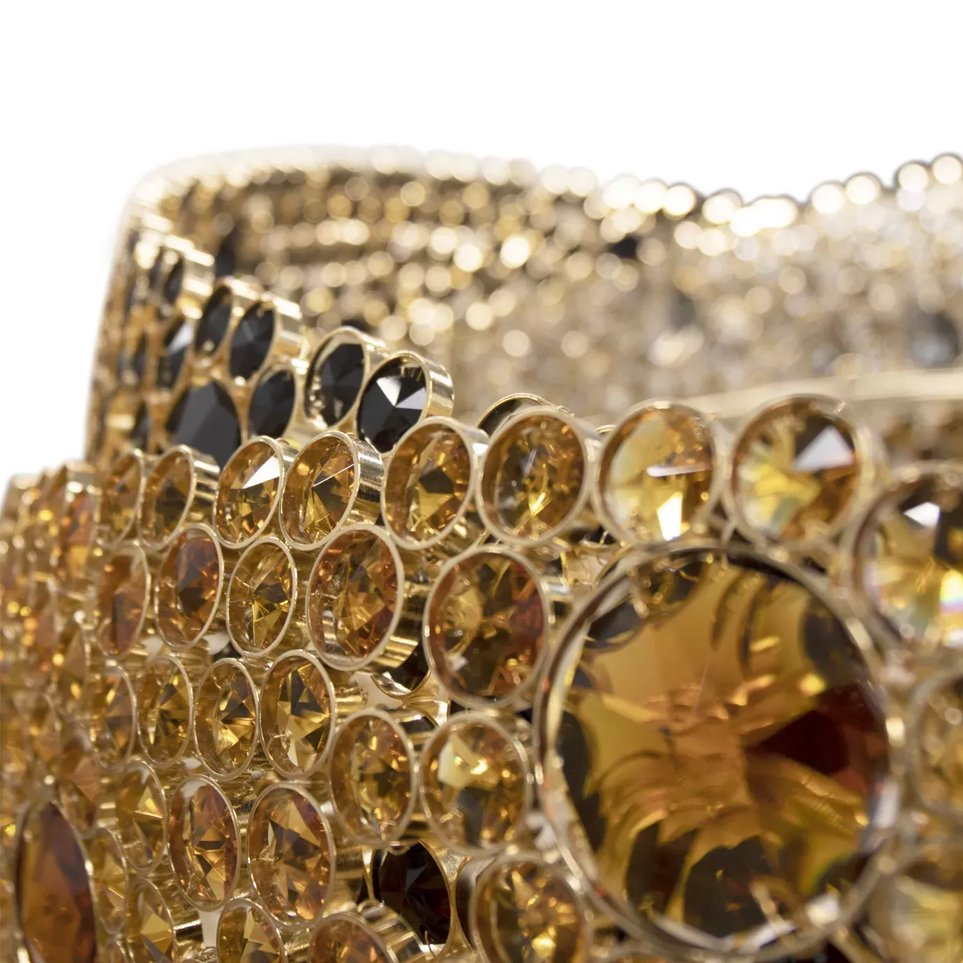 A close-up of the Trinity Chandelier shows intricate gold and black crystal details.