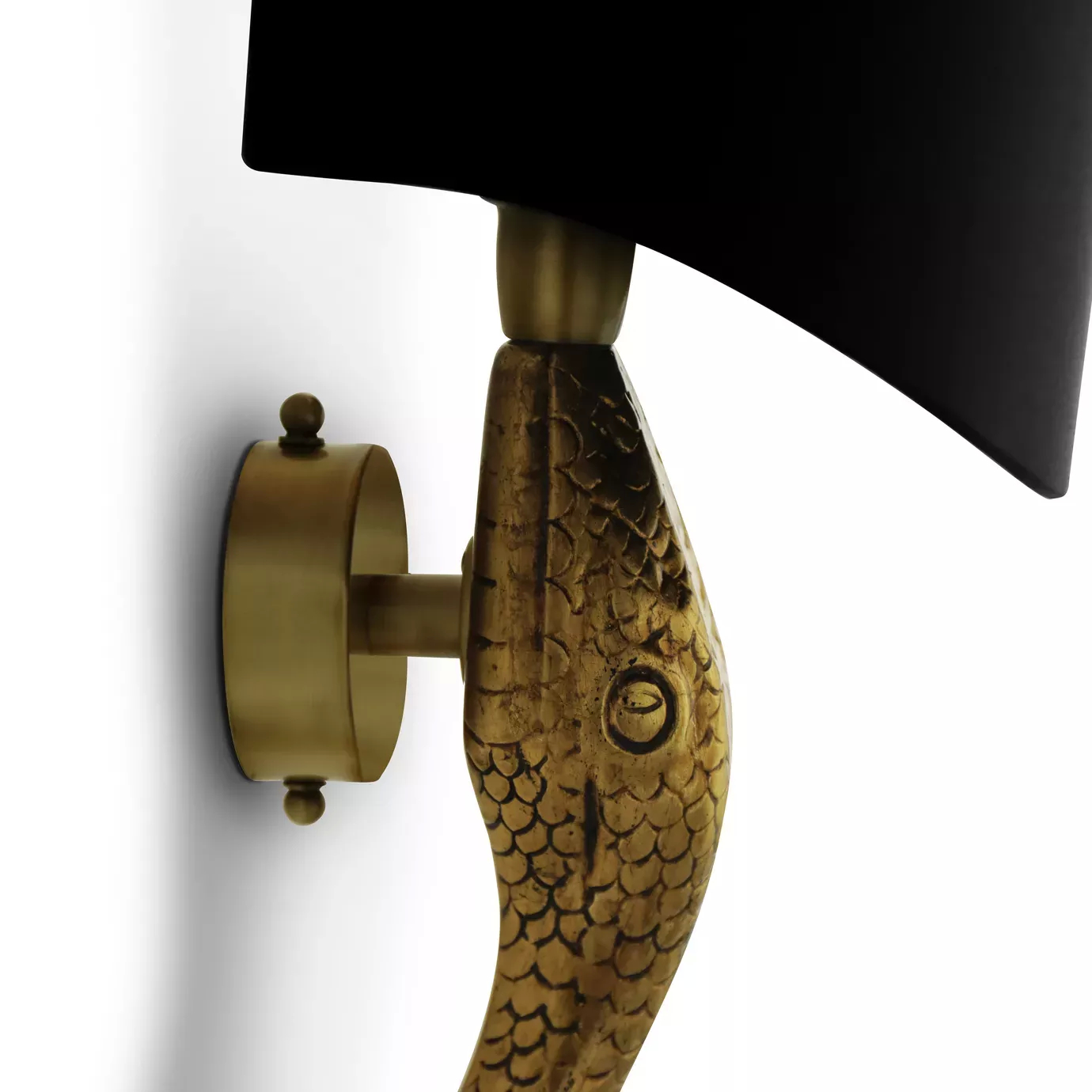 A close-up view of a gold Serpentine Sconce with a black shade, showcasing its textured, snake-like base.