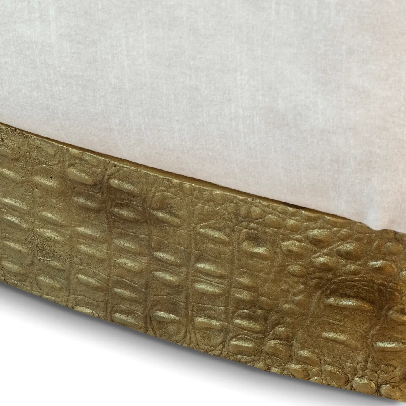 Gold embossed leather base of the Cleopatra Lounge Chair, showing detailed texture against a light background.