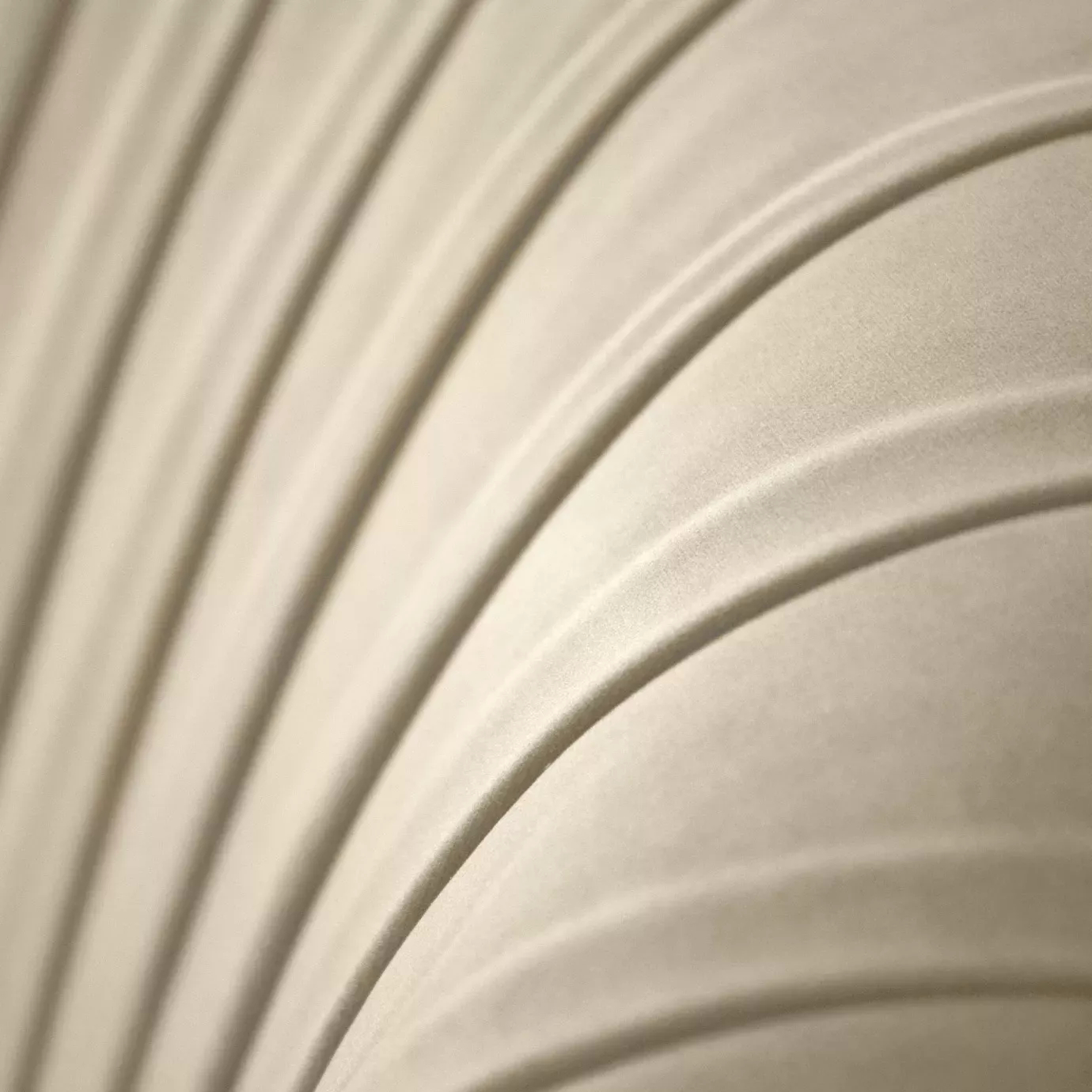 Close-up of cream velvet sofa upholstery with elegant fluted channel stitching and soft Art Deco-inspired curves.