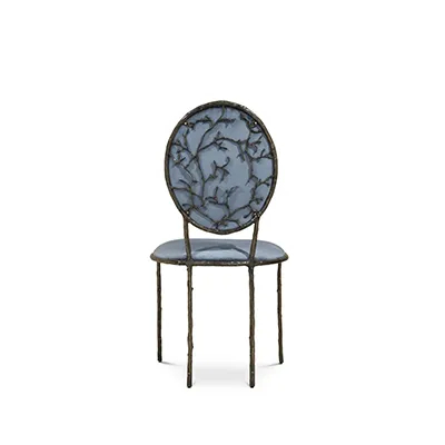 Featuring an elegant backrest resembling branches, the Enchanted Dining Chair has a luxurious blue upholstery.