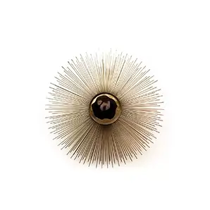 Elegant Brilliance Sconce with a sculptural radial design in golden tones and a dark, shiny central detail.