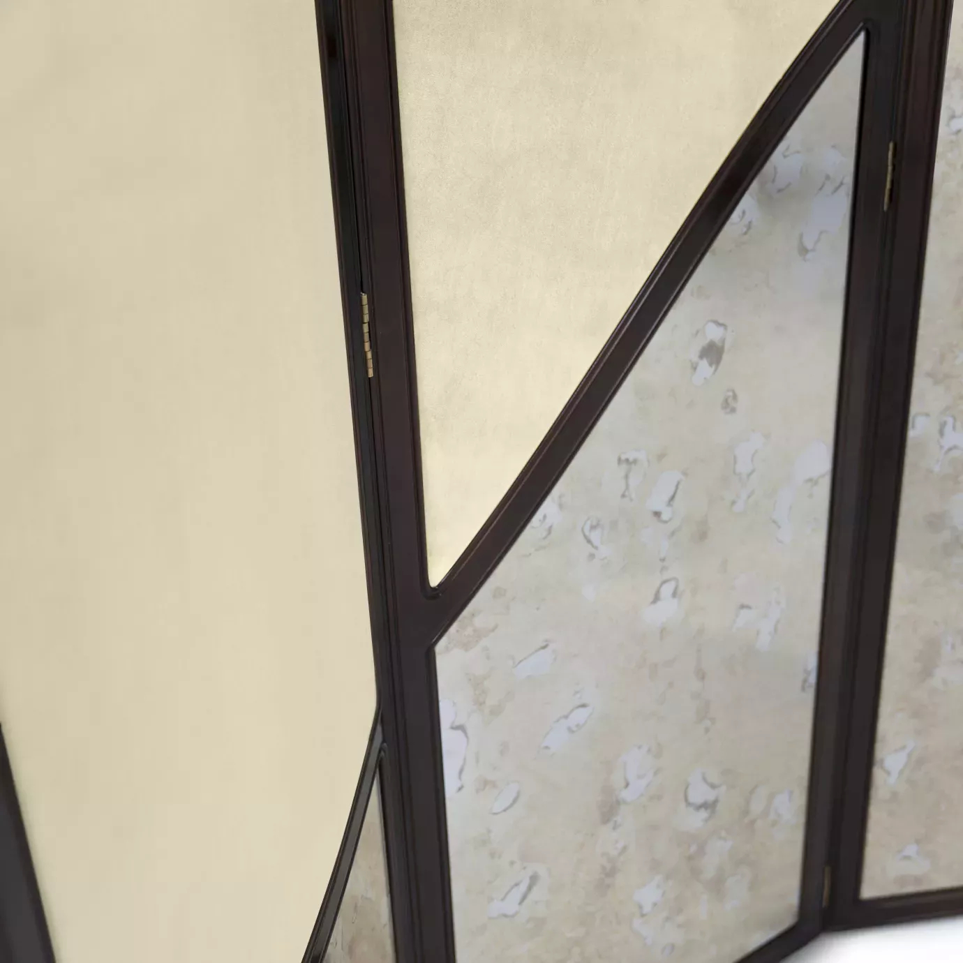 Elegant close-up of the detail of one of the Simone screen panels, showing the curved transition between the beige fabric at the top and the aged mirror at the bottom, framed by the dark structure.