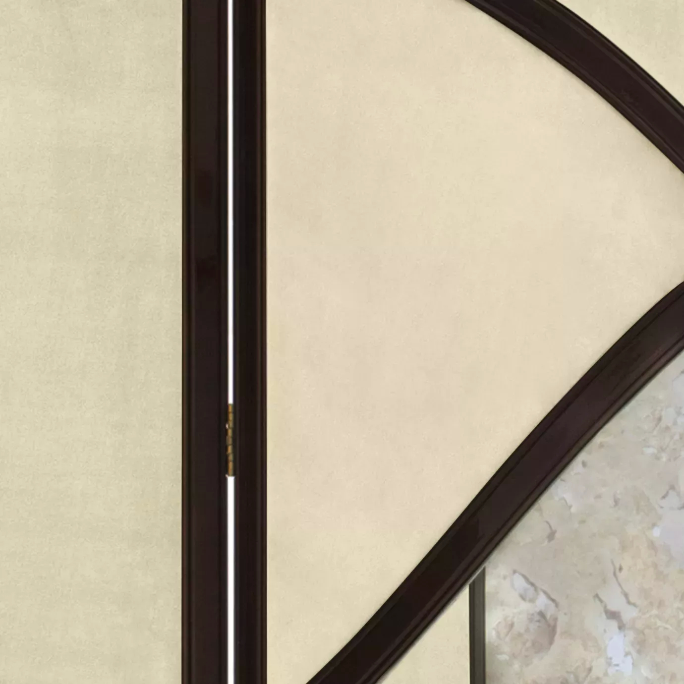 Elegant close-up of the golden hinge detail connecting two panels of the Simone screen, showing the beige fabric sections framed by the curved dark structure.