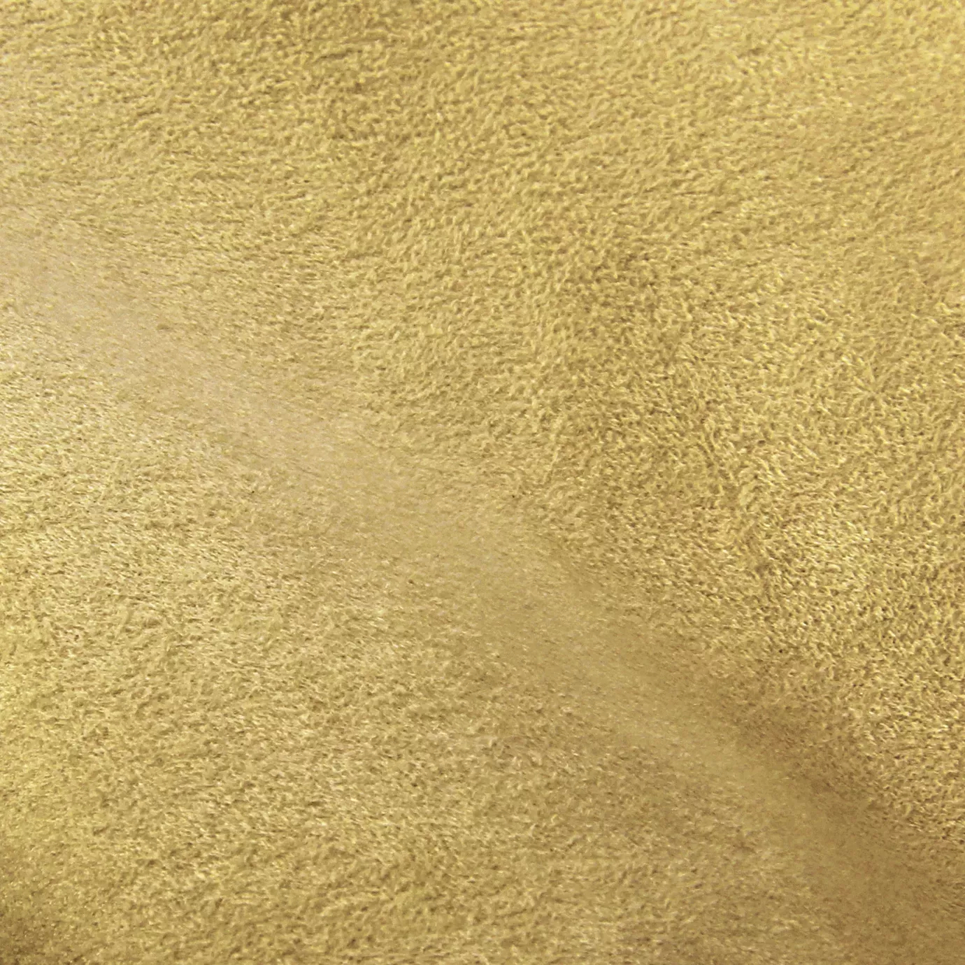 Soft close-up of an Ultra Suede fabric swatch in a warm and natural sandy beige tone, showcasing its soft texture and a delicate touch that gives it a feeling of comfort and casual elegance.