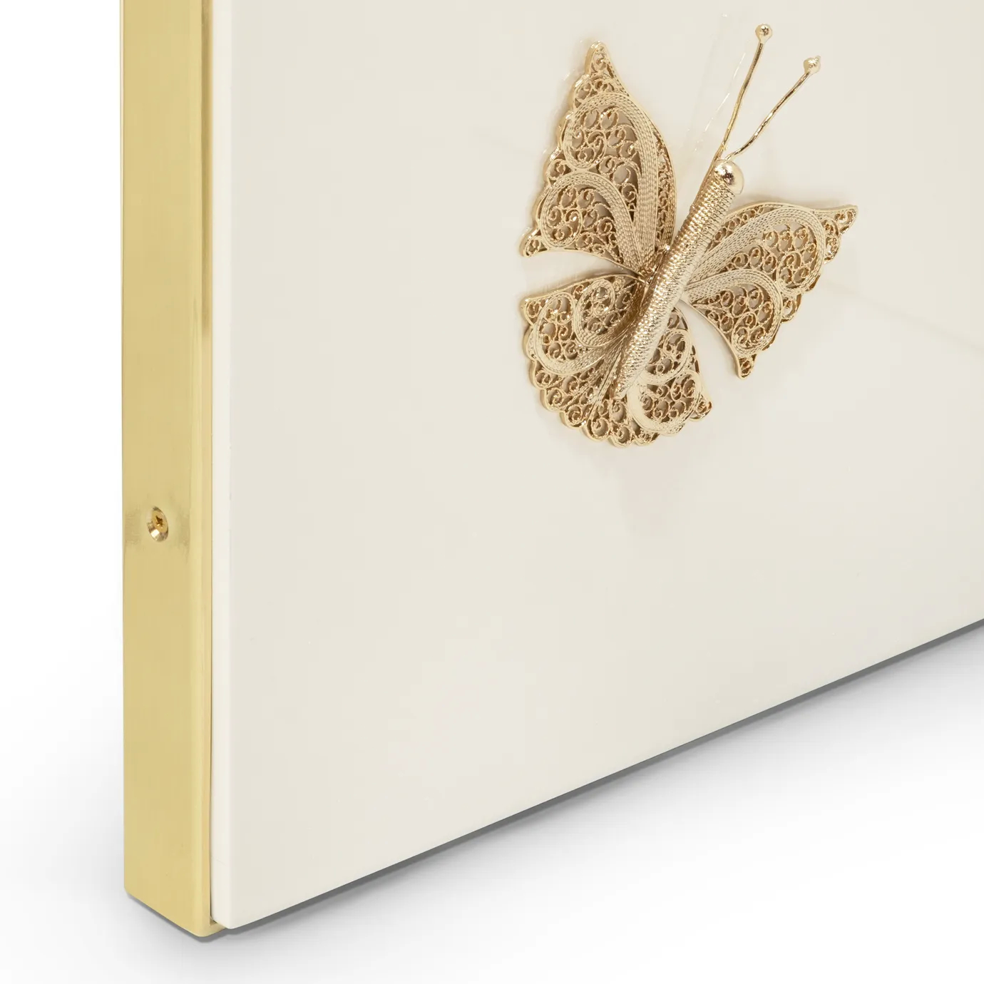Close-up of KOKET’s Euphoria Screen showcasing a delicate gold filigree butterfly detail over a high-gloss cream lacquered surface, framed in polished brass.