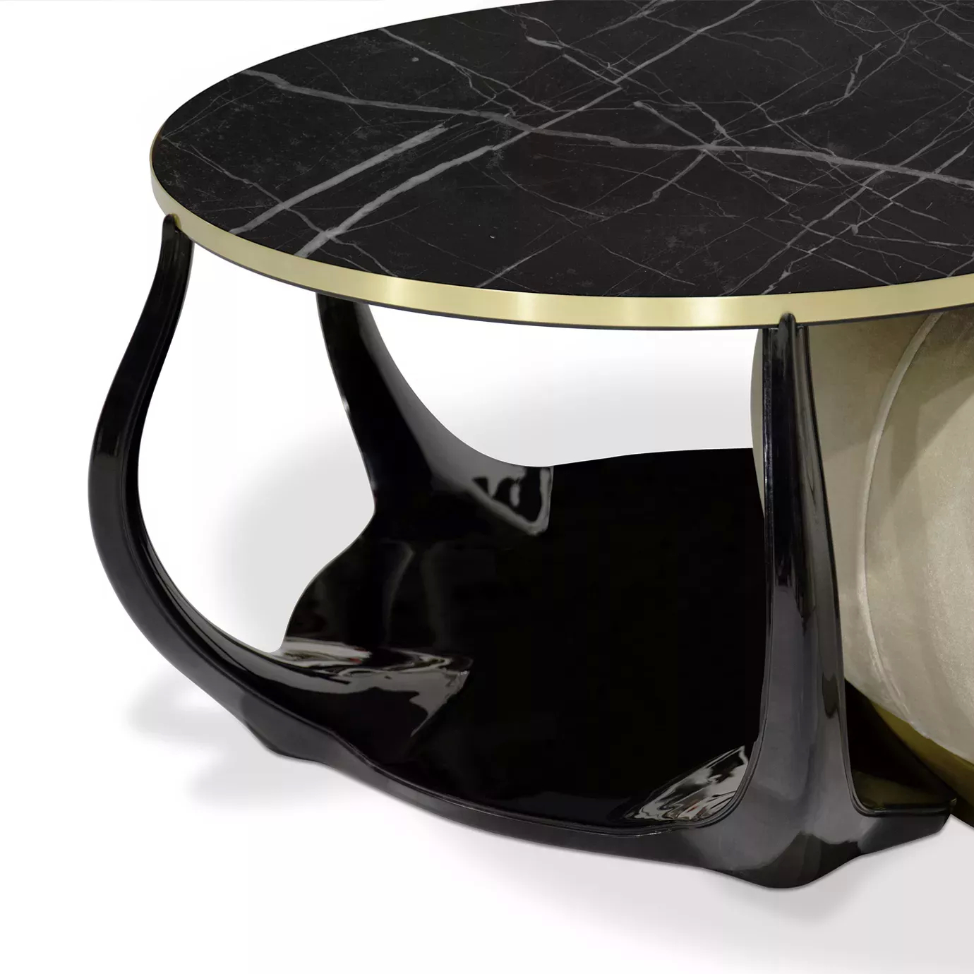Close-up of the Embrace Coffee Table: Black Nero Marquina marble top with gold trim resting on a plush cream velvet ottoman.