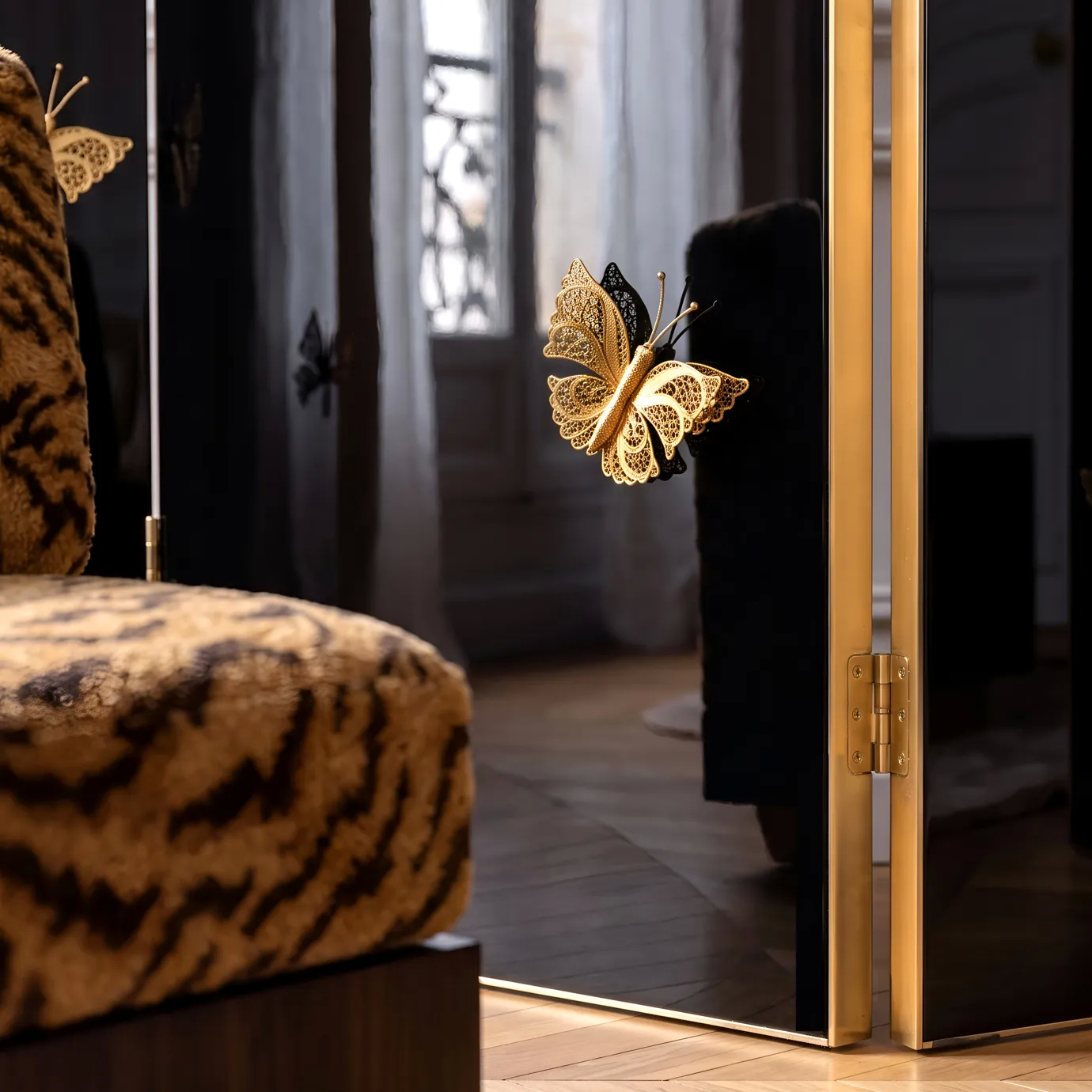 Detail of Euphoria screen by KOKET, a gold filigree butterfly on black lacquer by a polished brass hinge, in Paris.