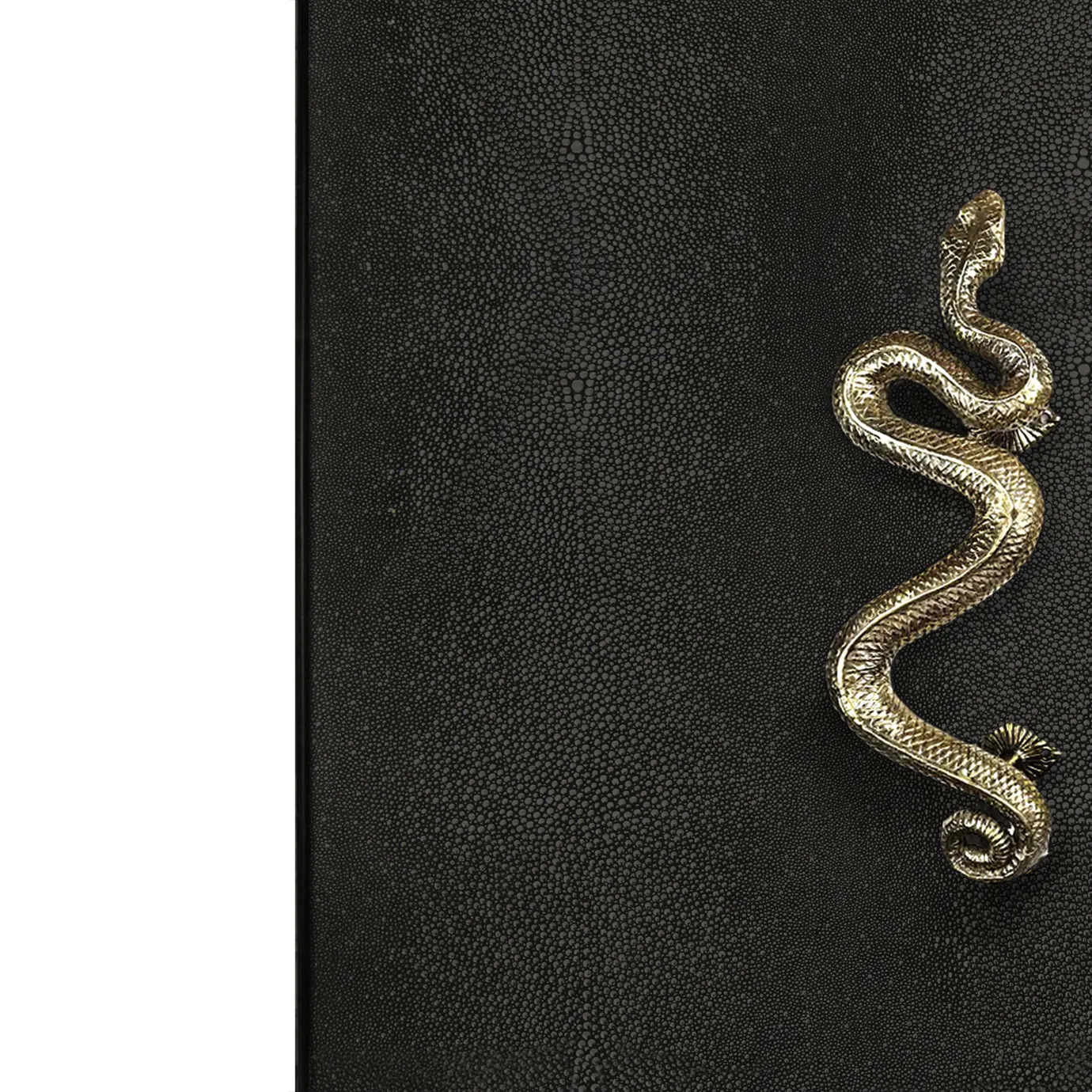 Close-up on the India Leather Bar Cabinet's golden serpent handle, detailed against the textured black leather door.