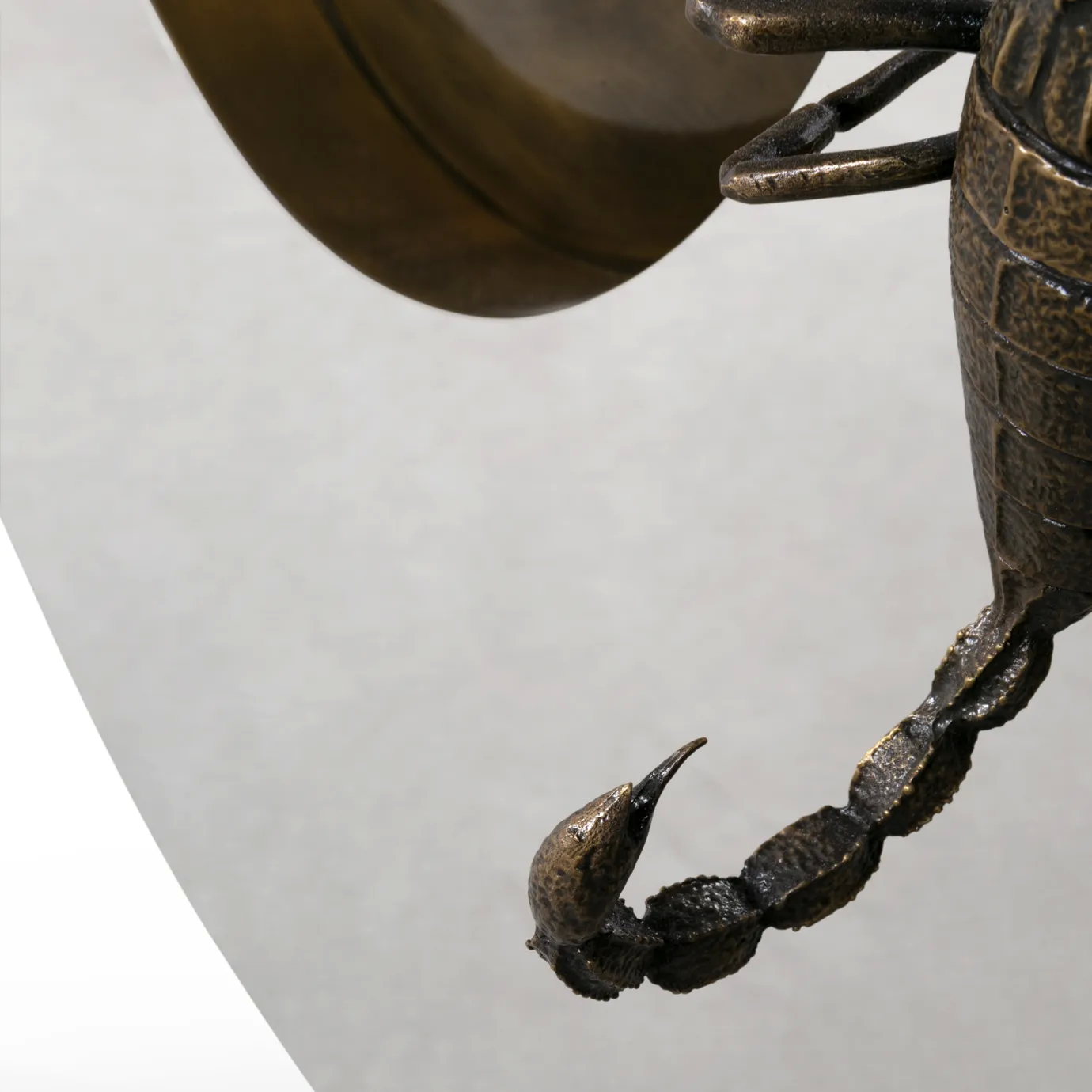 Close-up of Metamorphosis Console, highlighting the scorpion’s stinger with intricate sculptural detailing.