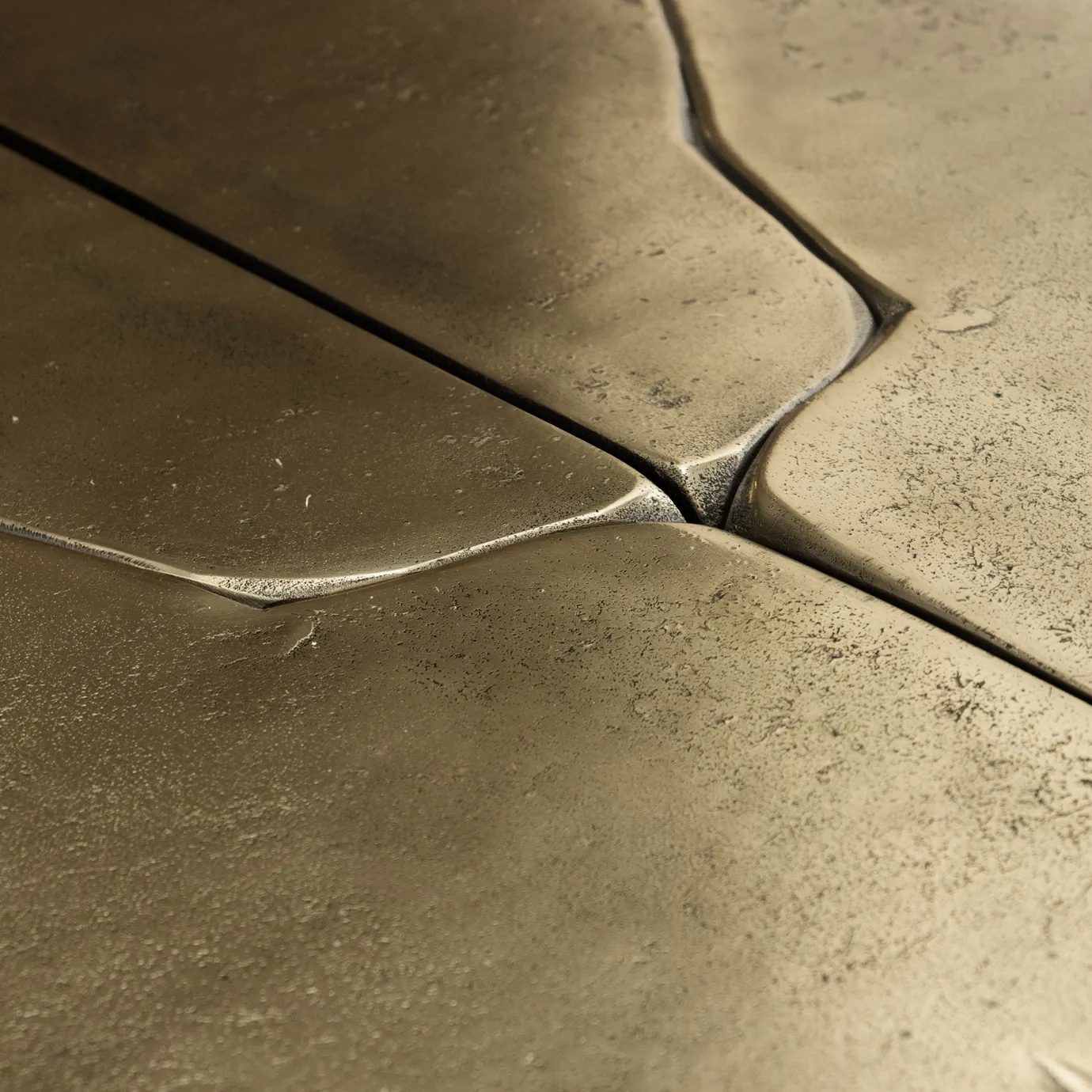 Extreme close-up of Lumiere Console’s gold console table, showcasing its textured surface and intricate detailing.