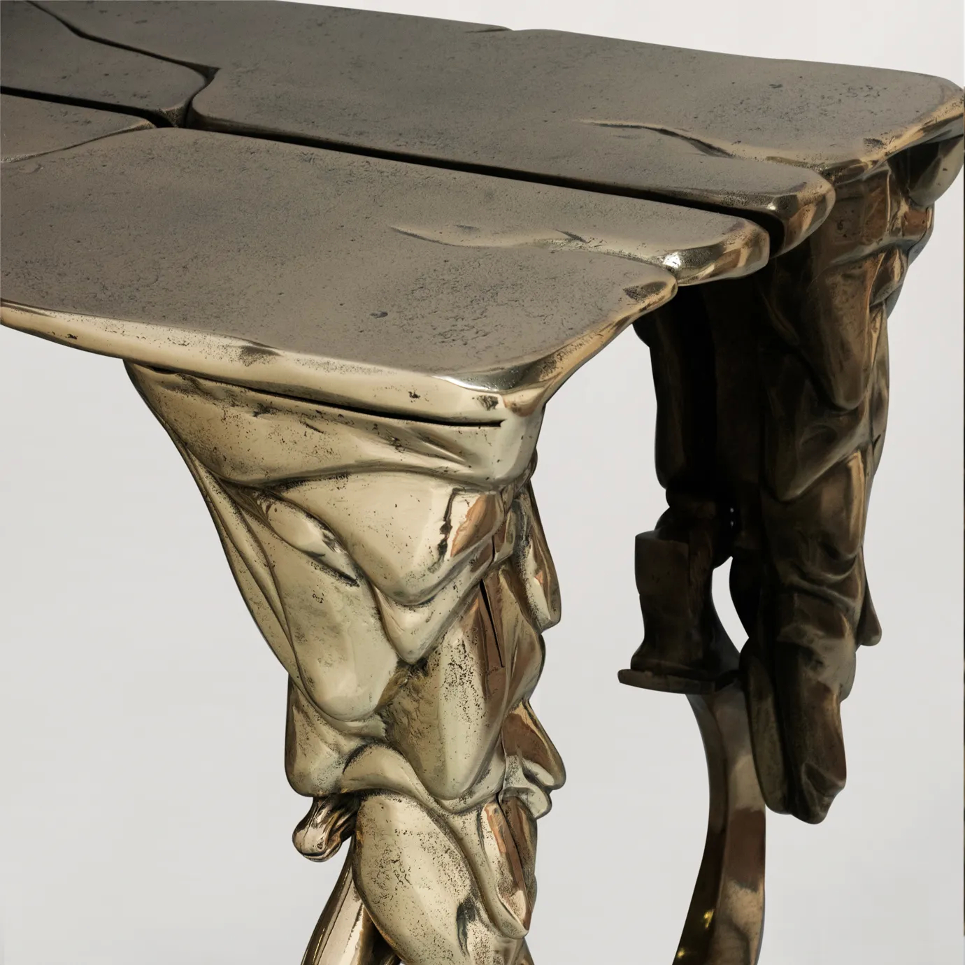 Close-up of Lumiere Console’s gold console table, highlighting its intricate, sculptural design and reflective surface.