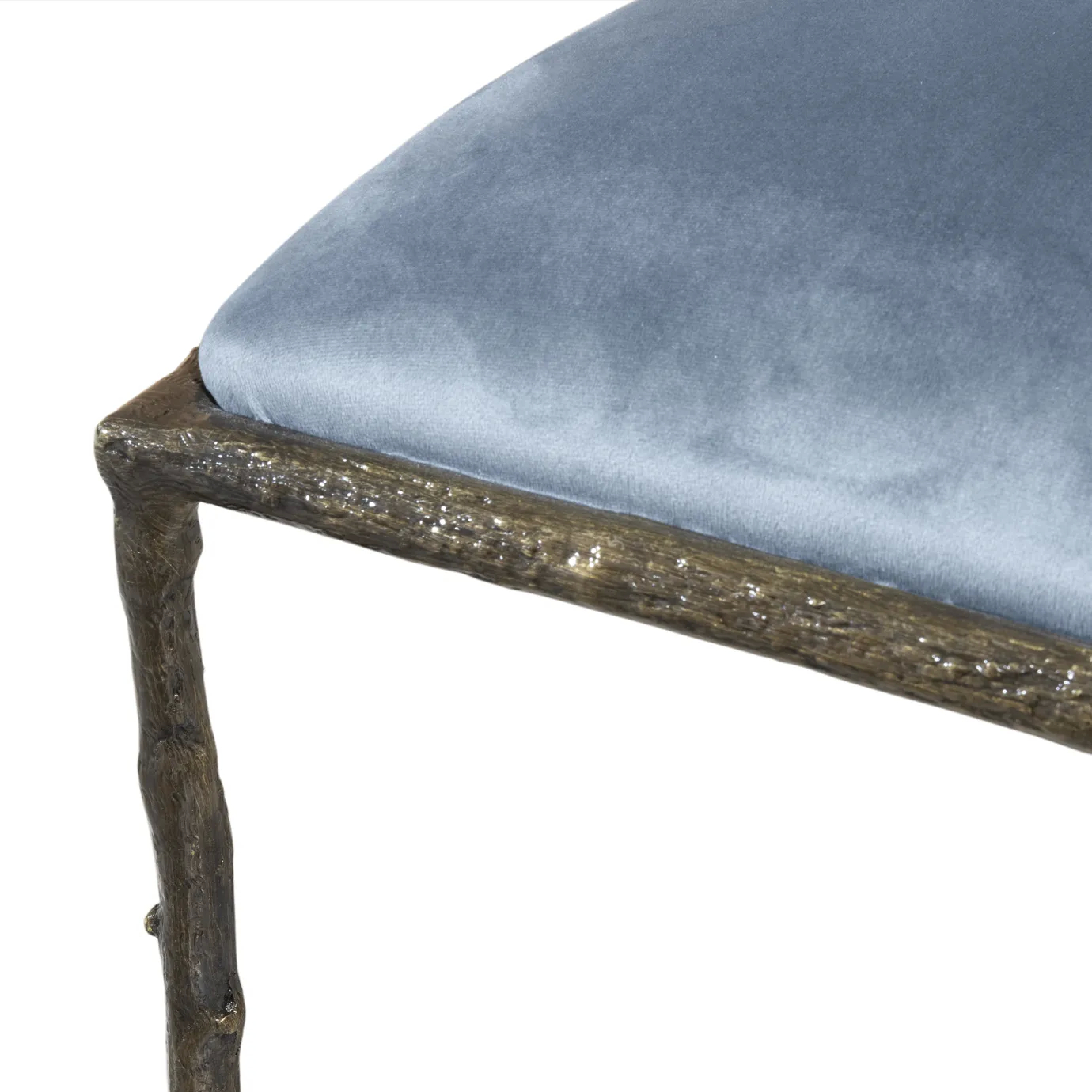 Close view of the Enchanted Dining Chair’s aged brass frame, combining with the luxurious blue upholstery.