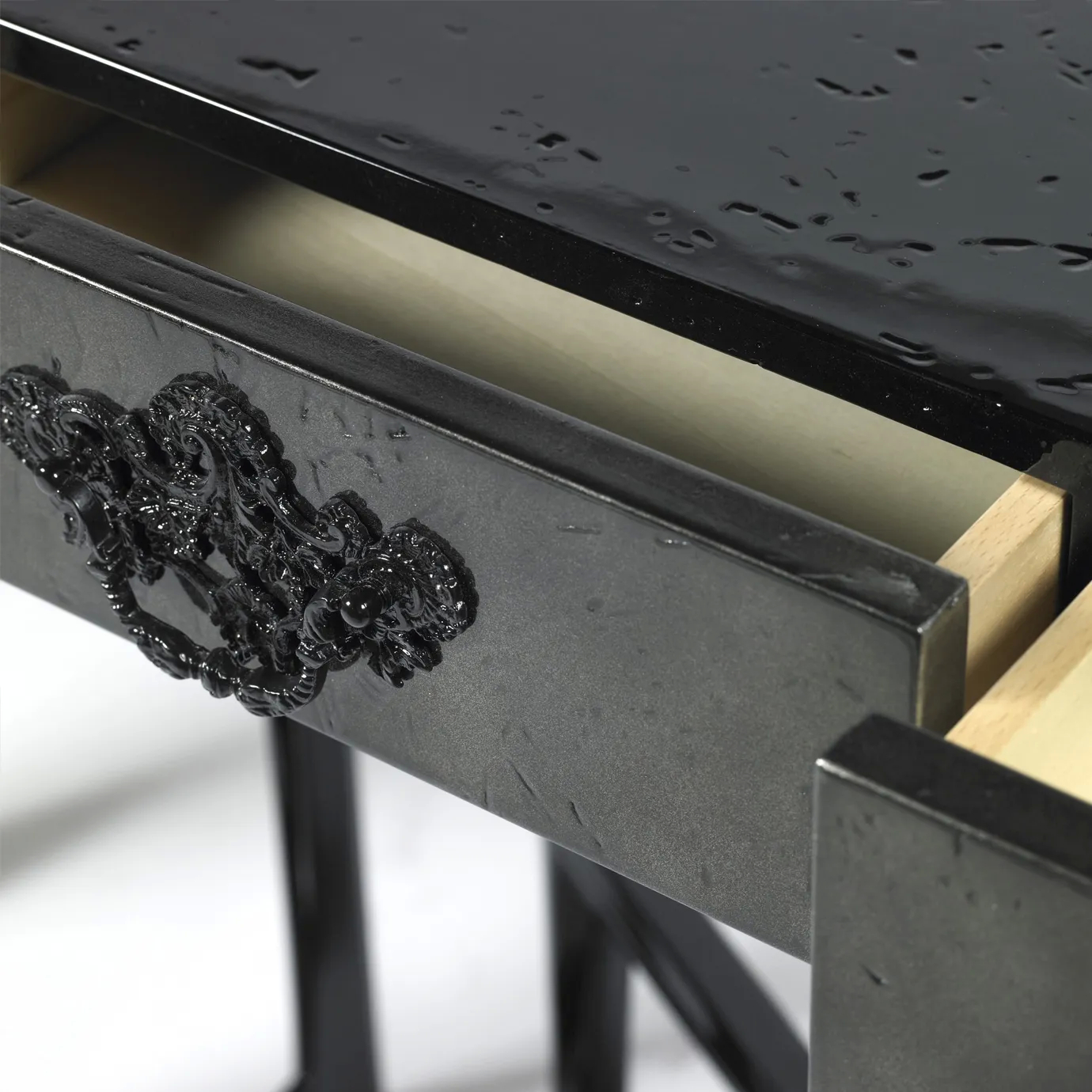 Side view of the sleek black console showcasing its sharp design and gold accents.