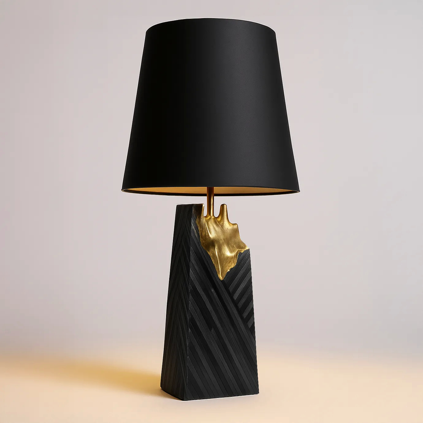 A luxurious Gild Table Lamp featuring a black shade, a textured black base, and a striking gold metallic accent.
