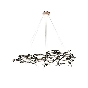 Rose Chandelier in aged brass with sculptural vine-like branches and delicate bud details, suspended by thin cables in a modern interior setting.