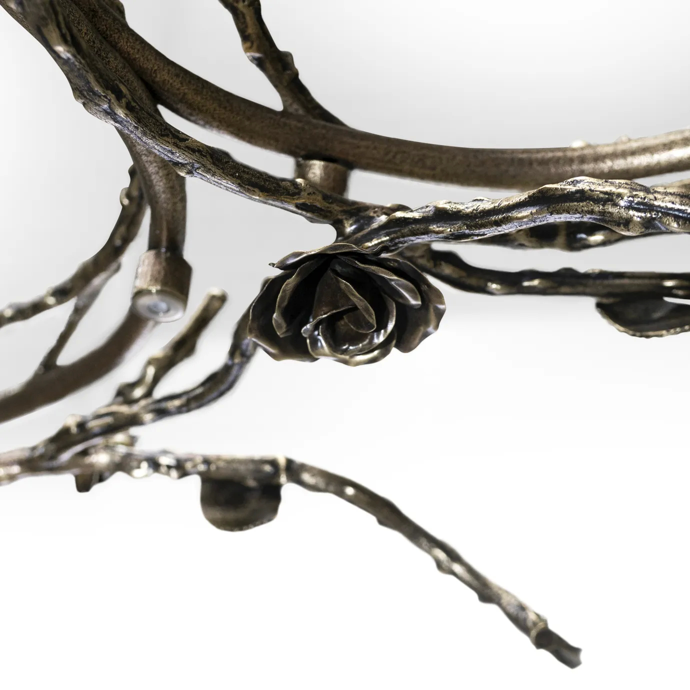 Rose Chandelier in aged brass with intricately crafted branches, leaves, and rose-shaped details, featuring circular frames with small bulbs in an ornate, nature-inspired design.