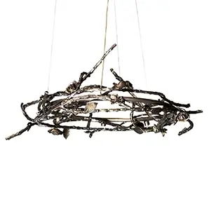 Rose Round Chandelier in aged brass with sculptural branches, metallic leaves, and rose-shaped accents, suspended by thin wires in a modern interior.