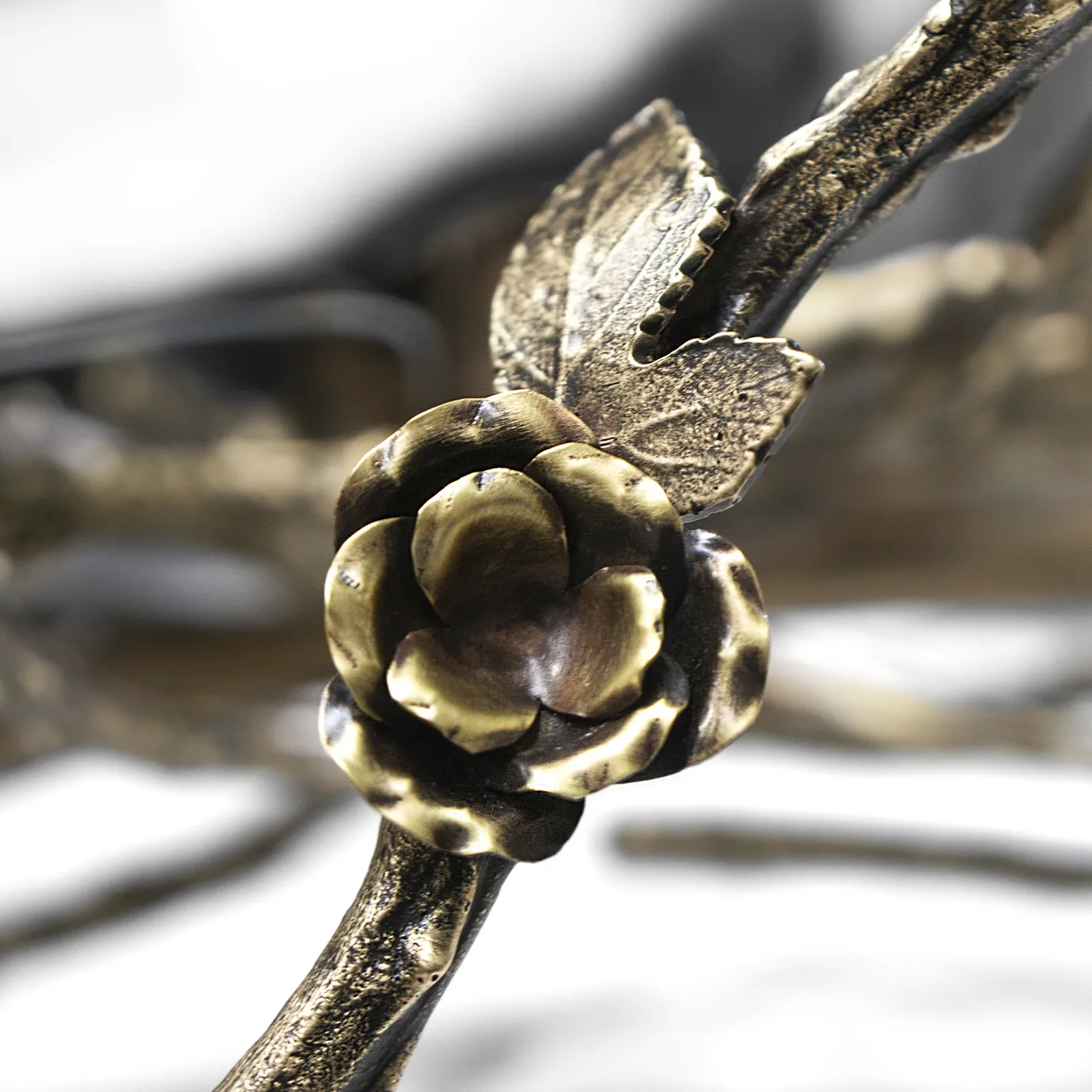 Close-up of the Rose Round Chandelier in aged brass, featuring sculpted rose and branch elements with antique finish and intricate metalwork craftsmanship.