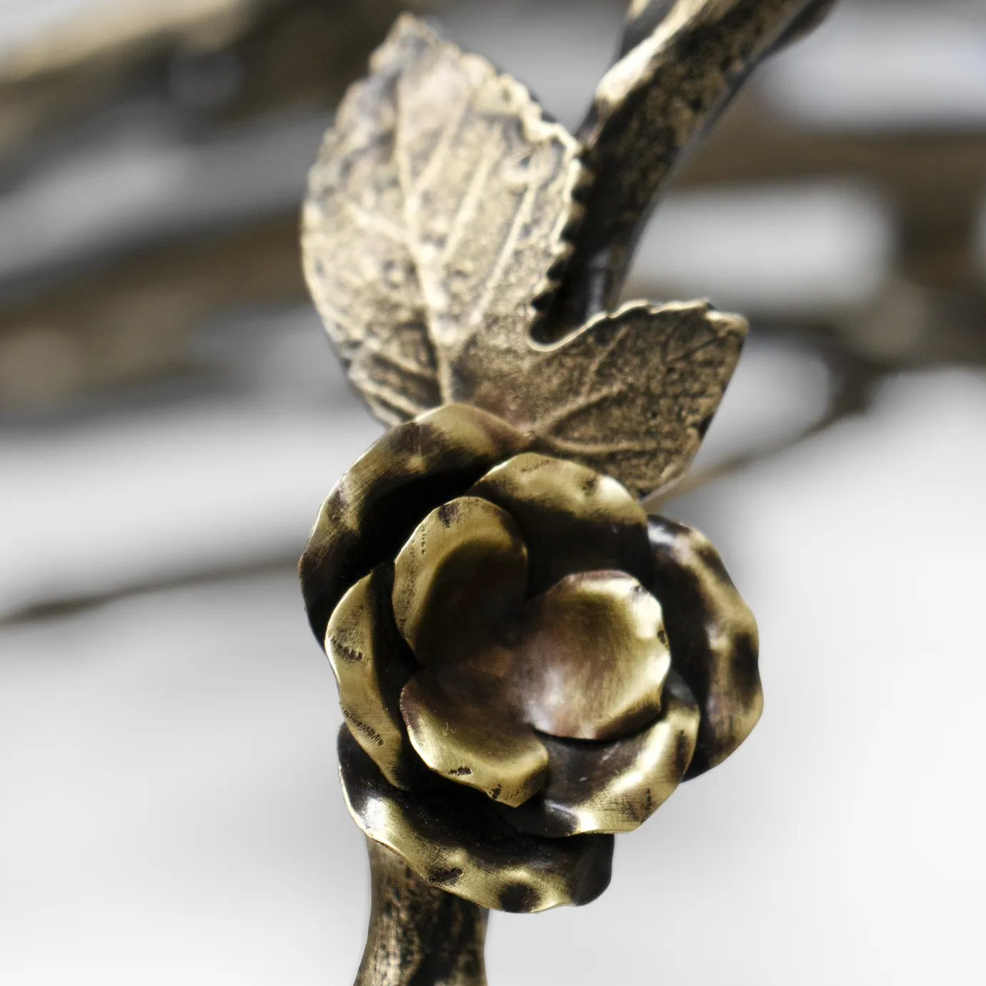 Close-up of the Rose Round Chandelier in aged brass, featuring sculpted rose and branch elements with antique finish and intricate metalwork craftsmanship.