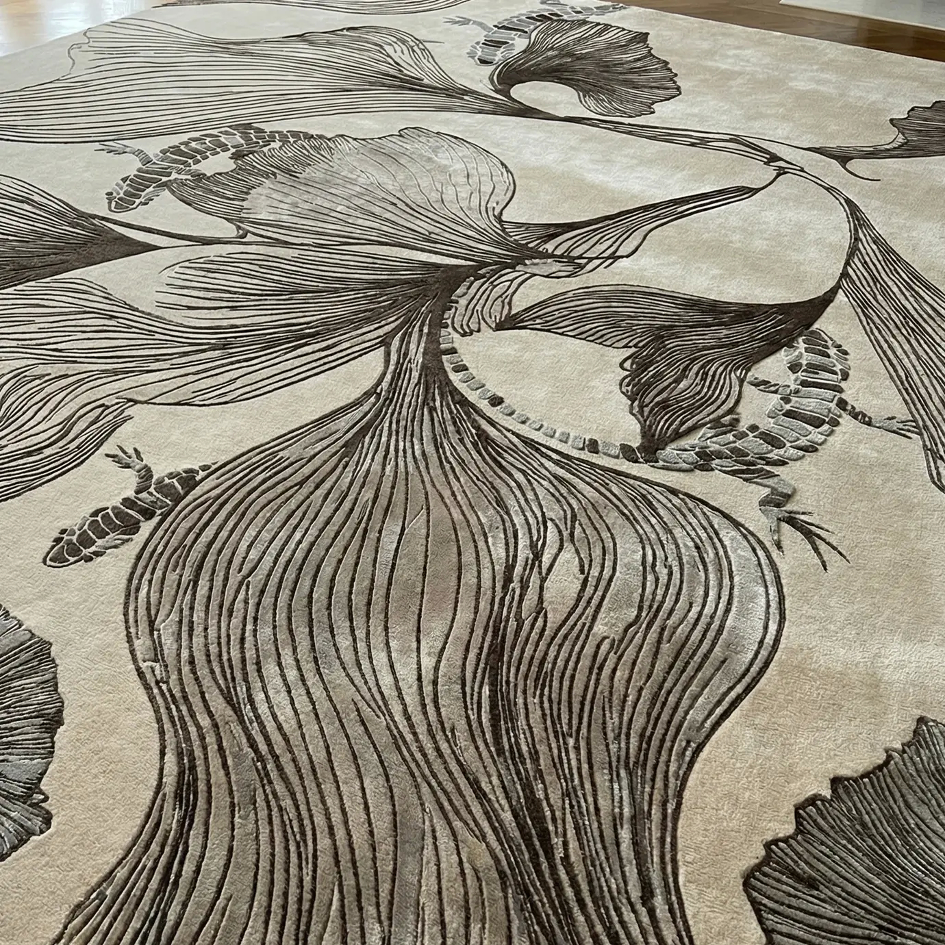 Detailed view of the KOKET Flora Grey luxury rug featuring hand-tufted botanical patterns and intricate lizard motifs in a sophisticated grey and cream palette.