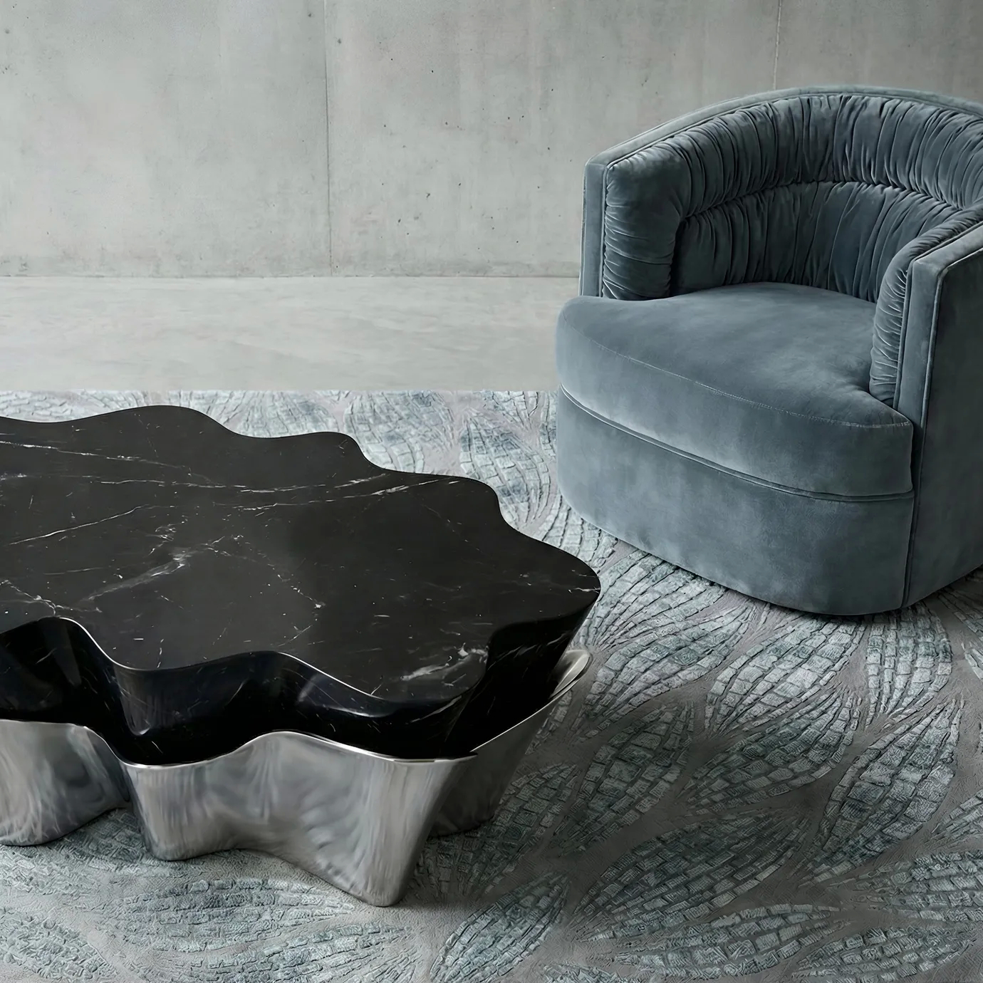 Yasmine Coffee Table by KOKET with sculptural silver metal base and black marble top, styled with the Cocktail Armchair and Terra Rug from KOKET’s luxury collection in a contemporary living room.