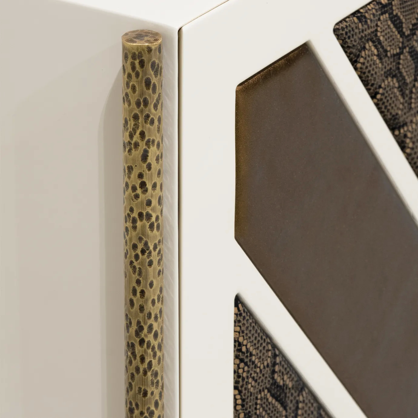 Brass structure and hinge detail on Opium Cream Cabinet highlighting construction precision