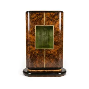 Eleanor armoire by KOKET in walnut burl, brushed brass door inlays and a brass-framed green display niche at center, front.