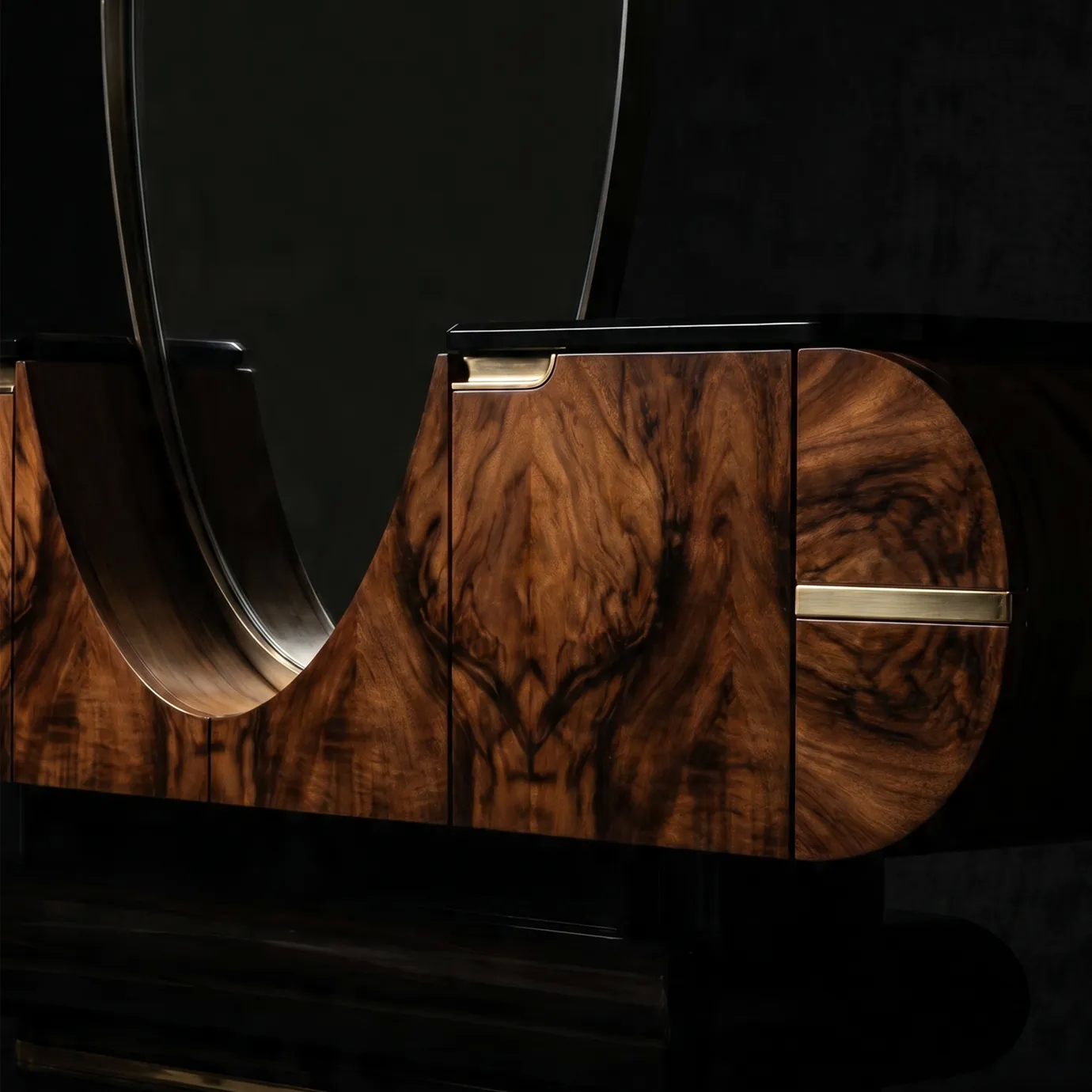 Elsa console table by KOKET on a dark background, where the oval mirror curves down into the book-matched walnut burl body.