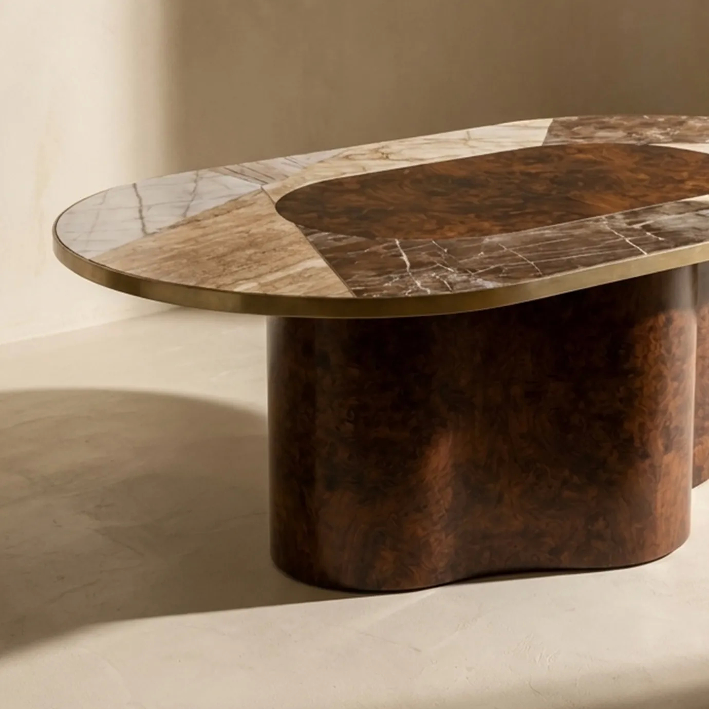 Close-up of KOKET Women Art Deco luxury dining table with marble inlay top, brass edge and sculptural wood veneer base.