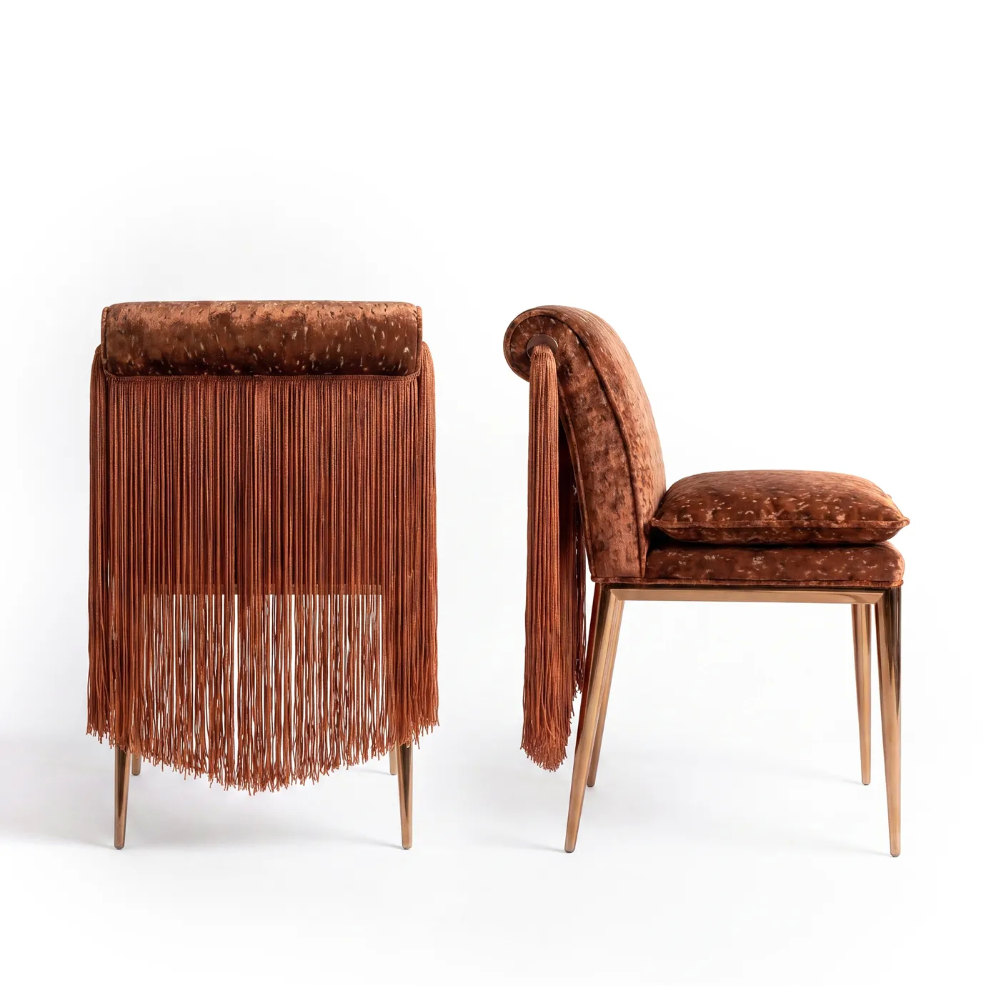 Lucienne dining chairs by KOKET shown from the back and side, with full cascading fringe over the rolled backrest.
